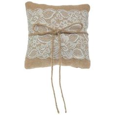 a pillow with lace on it and tied up to the side, sitting on a white background