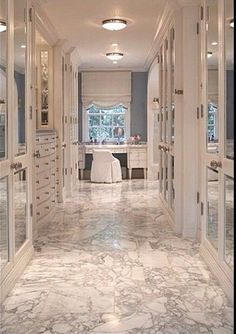 an elegant hallway with mirrored doors and marble flooring