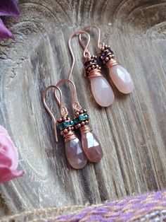 These petite little earrings measure at just 1.5 inches in length. They feature your choice of peach or chocolate moonstone with Swarovski crystal details. The peach moonstone pair comes with  deep purple Swarovski beads and the chocolate moonstone pair comes with teal crystals. Both pairs are wrapped with copper wire and have copper hooks. Teal Crystals, Crystals Purple, Fossil Earrings, Earrings Everyday, Swarovski Beads, Moonstone Earrings, Peach Moonstone, Moonstone Jewelry, Purple Crystals