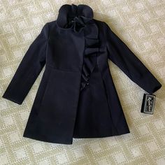 Rothschild Black Coat With Ruffle Detail. Size 7. New With Tags Fitted Black Pea Coat For Spring, Black Fitted Pea Coat For Spring, Fitted Black Peacoat With Pockets, Fitted Black Peacoat For Cold Weather, Black Fitted Peacoat For Cold Weather, Fitted Black Peacoat For Fall, Black Ruffled Outerwear For Fall, Silver Puffer Jacket, White Wool Coat