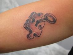 a piece of puzzle tattoo on the arm