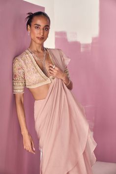 Editor's Note Elevate your style with our dusky pink net embroidered blouse, adorned with intricate embroidery on the elbow-length sleeves. Paired with a chiffon organza draped ruffled sari, this ensemble exudes grace and femininity. The soft and romantic hues of dusky pink, combined with the delicate ruffles and intricate embroidery, create a captivating look that is perfect for special occasions. The flowing drape of the sari adds an ethereal touch, while the embroidered blouse adds a touch of Light Pink Western Blouse, Saree Chiffon, Ridhi Mehra, Net Blouse, Net Blouses, Organza Blouse, Ruffle Saree, Draped Blouse, Sharara Set