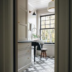 an open door leading to a kitchen with white cabinets