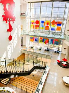 the inside of a building with many colorful paintings on the wall and stairs leading up to the second floor