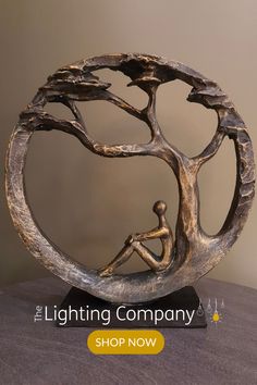 a bronze sculpture sitting on top of a wooden table next to a sign that says the lighting company