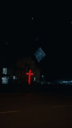 a red cross is lit up in the dark