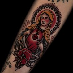 a woman's tattoo on the arm with roses and sunbursts around her