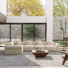 a modern living room with stone walls and large windows