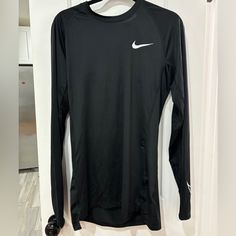 Elevate Your Workout Game With This Nike Men's Pro Dri-Fit Slim Fit Long-Sleeve Top. Designed With A Crew Neck And Pullover Closure, This Activewear Top Is Perfect For Gym & Training, Cycling, Baseball, Cross Training, Driving, Dance, Crossfit, Basketball, Bodybuilding, Running & Jogging. Made With A Blend Of Polyester And Spandex, This Lightweight And Breathable Top Features Slimming And Moisture-Wicking Properties, Making It Ideal For All Seasons. The Black Color And Solid Pattern With A Nike Nike Fitted Sports Shirt, Nike Fitted Shirt For Sports, Fitted Nike Sports Shirt, Fitted Nike Shirt For Sports, Black Long Sleeve Workout T-shirt, Black Long Sleeve Sports Shirt, Baseball Cross, Workout Games, Gym Training