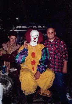 two men are standing next to a clown