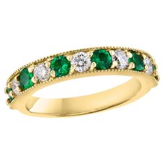 a yellow gold ring with green and white stones