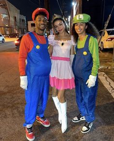 three people dressed up as mario and luigi from mario bros posing for a photo together