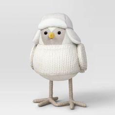 a stuffed bird wearing a white sweater and hat