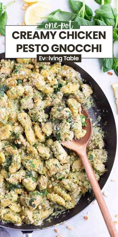 a skillet filled with creamy chicken pesto gnocchini next to lemon wedges