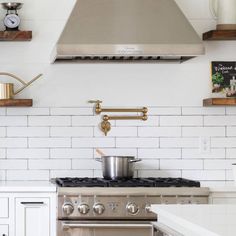 a stove top oven sitting inside of a kitchen next to white cabinets and counter tops