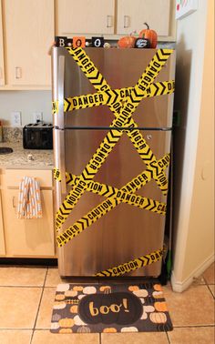 a metallic refrigerator covered in yellow caution tape