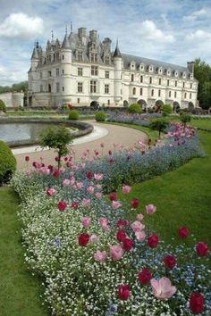 a large building with lots of flowers in front of it