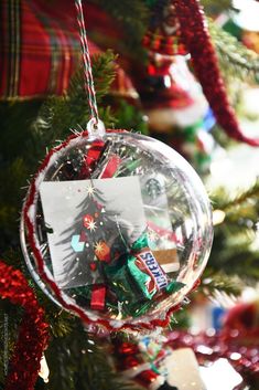 an ornament hanging from a christmas tree decorated with candy bars and candies