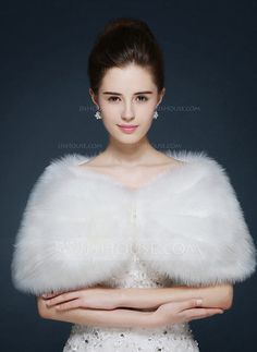 a woman in a white dress with a fur stole on her shoulders and arms crossed