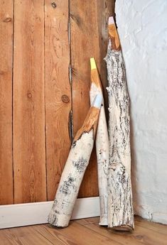 two pieces of wood sitting next to each other on the floor in front of a wooden wall