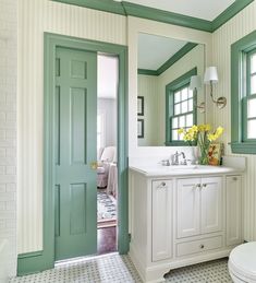 a bathroom with green trim and white fixtures