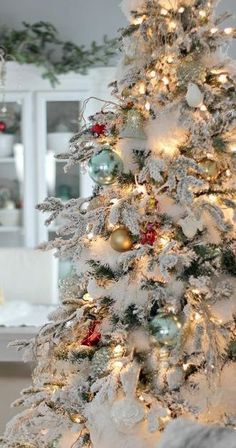 a white christmas tree decorated with ornaments and lights