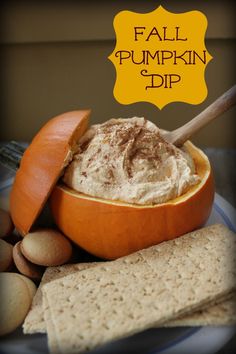 an orange bowl filled with pumpkin dip surrounded by crackers