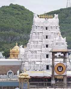 a large white temple in the middle of a forest