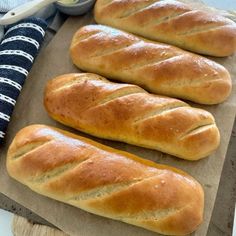 three loaves of bread sitting on top of a cutting board