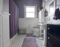 a bathroom with white and purple walls, black and white tile flooring and a toilet