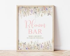 a sign that says bloom bar next to a white wall with flowers and butterflies on it