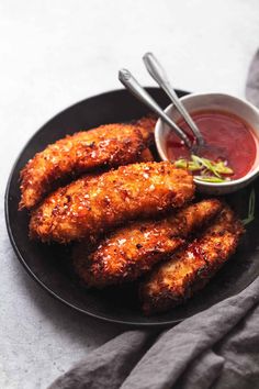 some fried food on a black plate with dipping sauce