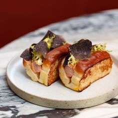 two pieces of bread with toppings sit on a plate