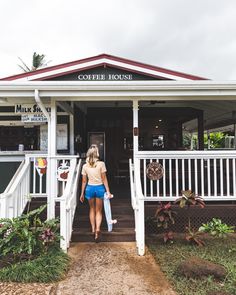 a woman is walking into a coffee house