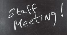 a blackboard with the words staff meeting written in white chalk on it's side