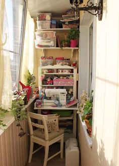 a sewing machine sitting on top of a wooden table next to a window filled with potted plants