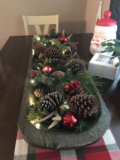 the table is decorated with pine cones and ornaments