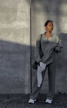 a woman standing in front of a concrete wall