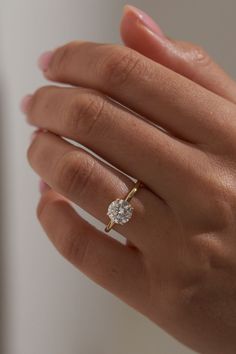 a woman's hand with a diamond ring on it