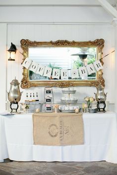 a table with a sign that says happy birthday hanging from it's side and some teapots on top