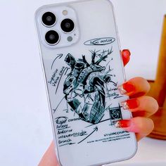 a woman holding up her phone case with an image of a human heart on it