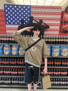 a young man standing in front of a display of soft drinks