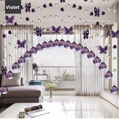 the living room is decorated in purple and white colors with crystal balls hanging from the ceiling