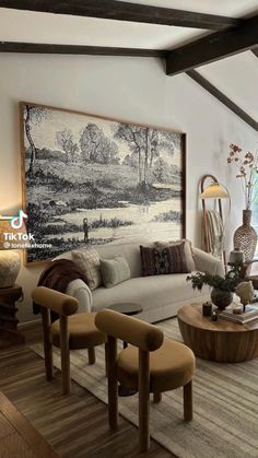 a living room filled with furniture and a painting on the wall