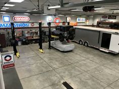 the inside of a car repair shop with cars and trucks on display in the garage