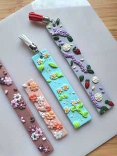 four different types of flowered paper clips on a cutting board