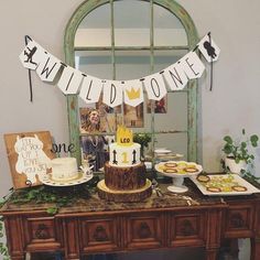 a table topped with a cake covered in white frosting next to a mirror and window