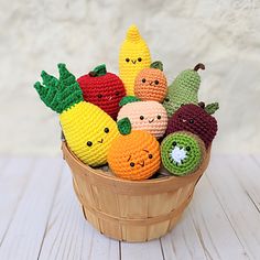 small crocheted fruits and vegetables in a basket on a wooden table with white background