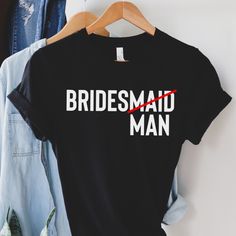 the bridesmaid man t - shirt is hanging on a hanger next to jeans