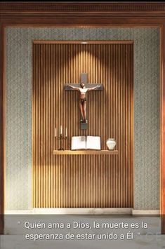 an empty room with a crucifix on the wall and candles in front of it